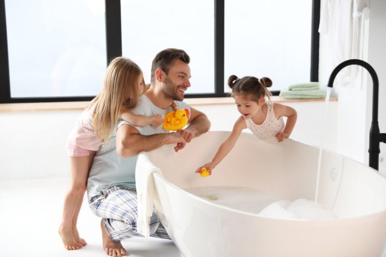 Dad and daughters filling up bathtub