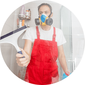 man cleaning shower with mask on